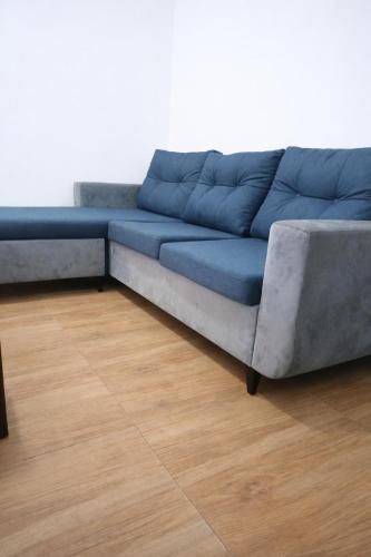 a blue couch in a room with a wooden floor at Cj apartment kasoa in Kasoa