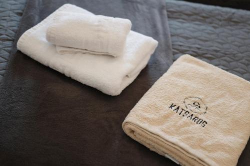two towels sitting on top of a bed at Katsaros Studios & Apartments in Sidari