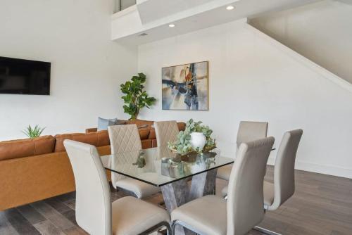 a dining room with a glass table and a couch at Penthouse Luxe Views No 604 in Dallas
