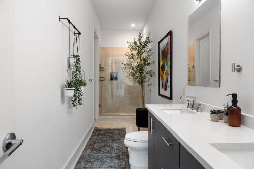 a bathroom with a toilet and two sinks and a shower at Penthouse Dallas no 603 in Dallas