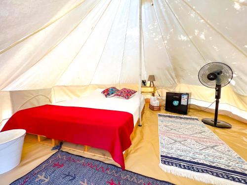 a bedroom with a bed and a fan in a tent at Ruina Glamping in Mezgit