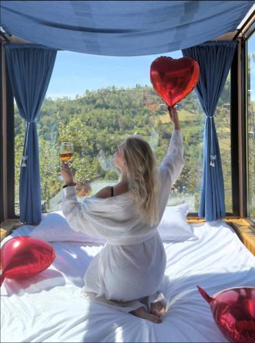 a woman holding a heart and a glass of wine at Hill House Merisi in Merisi