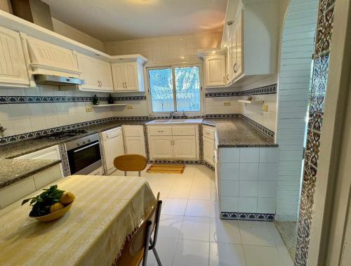 a kitchen with a table with a bowl of fruit on it at Villa Jasmin in Hammamet