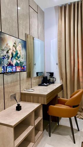 a room with a desk with a chair and a mirror at Purple Lavender Hotel Lekki in Lekki
