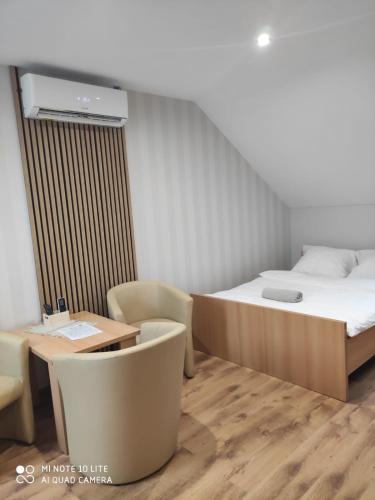 a bedroom with a bed and a table and chairs at Pokoje Gościnne Leśna 33 in Sława