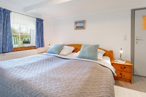 a bedroom with a large bed with blue pillows at Alte Dorfstraße 29 REETungsboot in Behrensdorf