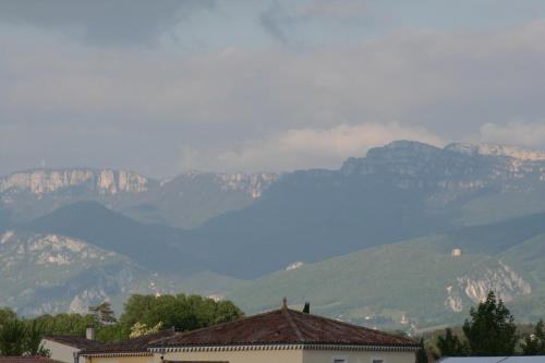 a view of a mountain range with houses and mountains at Hôtel Valery in Montélier