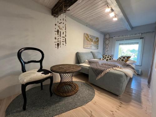 a living room with a couch and a table and a chair at Tiny House Ostsee # Naturwerk in Pruchten