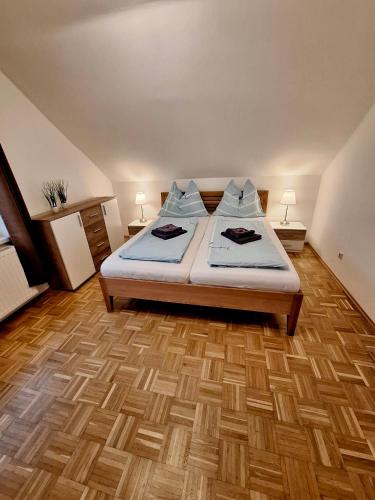 a bedroom with a bed and a wooden floor at Ferienhaus Wolfi in Eberndorf