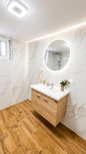 a bathroom with a sink and a mirror at MariosGuestHouse in Ancient Epidauros
