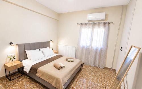 a bedroom with a large bed and a window at MariosGuestHouse in Ancient Epidauros