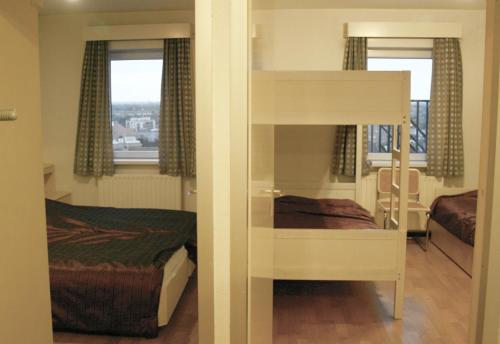 1 dormitorio con litera, 1 cama y ventana en Isola Bella Blankenberge, en Blankenberge