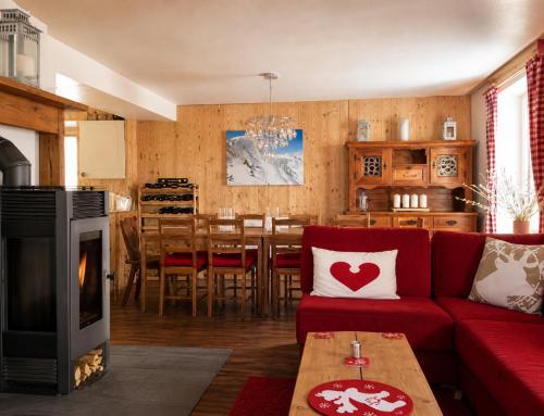 a living room with a red couch and a fireplace at Ferienhaus Jenig in Jenig