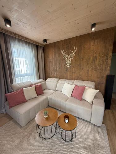 a living room with a white couch and two tables at Apartmán Forest, Tatranská Štrba in Tatranska Strba
