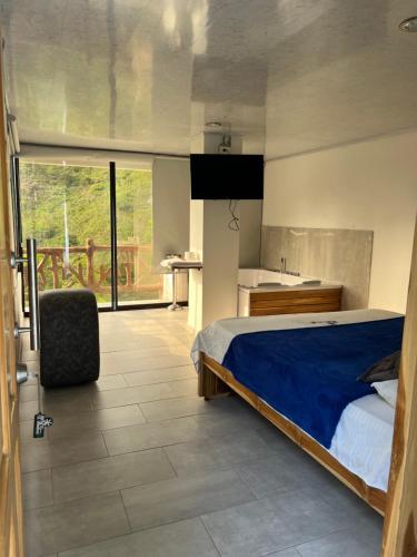 a bedroom with a large bed and a kitchen at Eco hotel el molino in San Luis