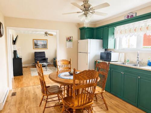 a kitchen with a table and chairs and a refrigerator at Long Beach Lookout Vacation Rental in Twillingate