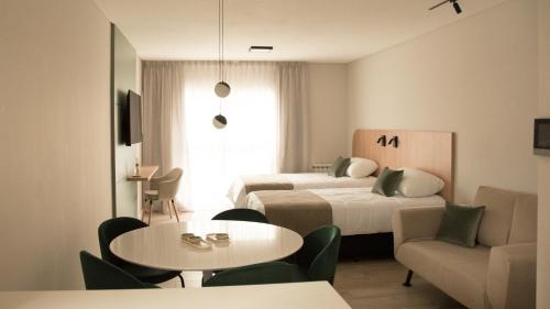 a hotel room with two beds and a table and chairs at VAYU LuxuryLofts in Bahía Blanca