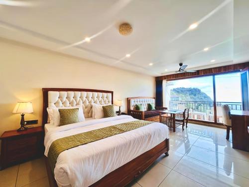 a bedroom with a large bed and a balcony at Mokshada Hotel & Resort A Premium Property Near Jaypee in Mussoorie
