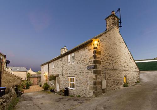 an old stone building with a light on it at West end cottage and shippon in Eyam
