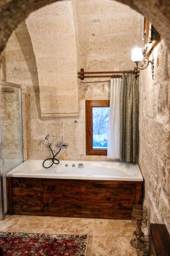 a large bathroom with a tub and a window at Masar Cave Konak in Ortahisar