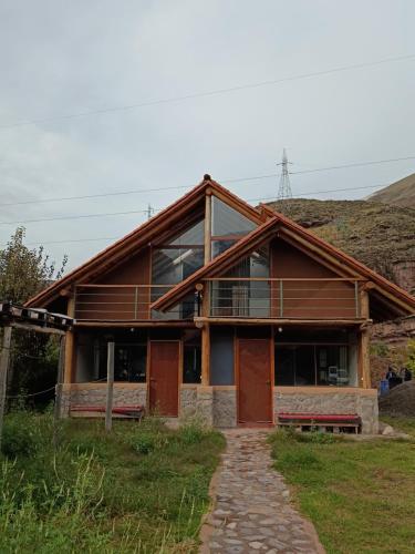 a log house with a pathway in front of it at Mrs Sapo Chalets in Urubamba