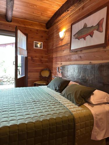 a bedroom with a bed with a fish picture on the wall at Trout Lodge in Collagna