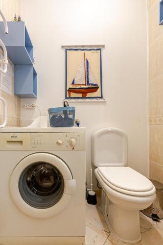 a bathroom with a toilet and a washing machine at Dunas de vilamoura in Quarteira