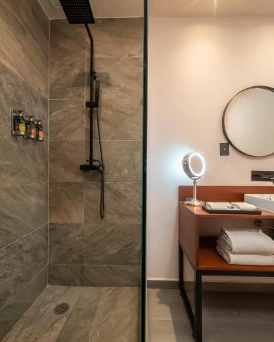 a bathroom with a shower and a vanity with a mirror at Casa de la Luz Hotel Boutique in Mexico City