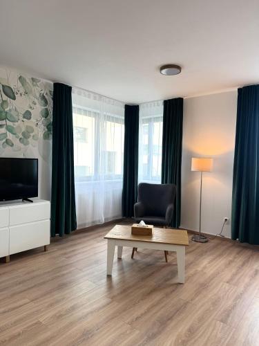 a living room with a coffee table and a television at VIRIDIS Apartment in Františkovy Lázně