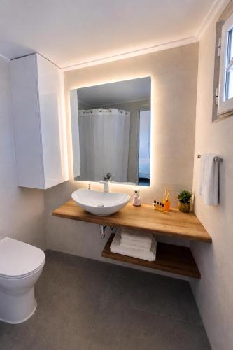 a bathroom with a sink and a toilet and a mirror at Sesi Luxury Suites Seaside & Private Pool in Marathon