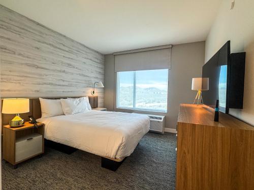 a hotel room with a bed and a large window at TownePlace Suites by Marriott Ridgecrest in Ridgecrest