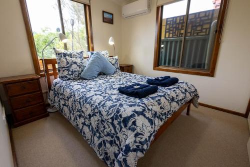 a bedroom with a bed with two blue towels on it at Flinders Ranges Bed and Breakfast in Hawker