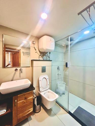 a bathroom with a toilet and a sink and a shower at Mokshada Hotel & Resort A Premium Property Near Jaypee in Mussoorie