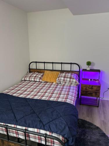 a bedroom with a bed and a purple night stand at Restful Basement Suite Hideaway in Saskatoon