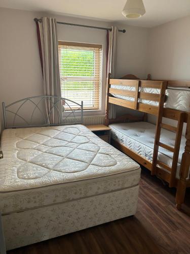 a bedroom with two bunk beds and a window at Central Two Bed Apartment looking over the Harbour in Dunfanaghy
