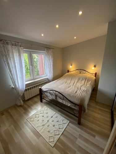 a bedroom with a bed and a window at Mazurski Dom Rodzinny in Pisz