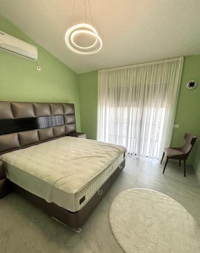 a bedroom with a bed and a chair and a window at Villa in Čeluga