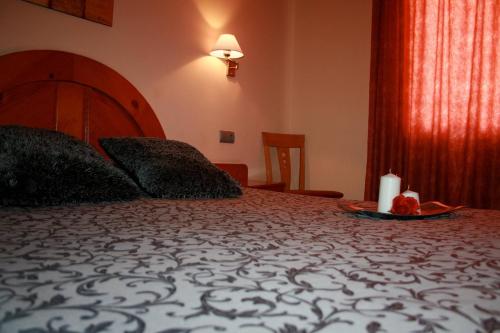 a bedroom with a bed with a candle on a tray at El Pinche de Oro in Benicarló