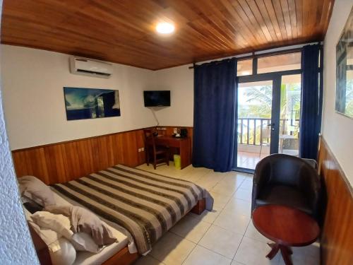 a bedroom with a bed and a desk and a chair at Hotel Palm Rock Beach in San-Pédro