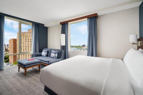 a hotel room with a bed and a chair and windows at Courtyard by Marriott New York Manhattan Upper East Side in New York