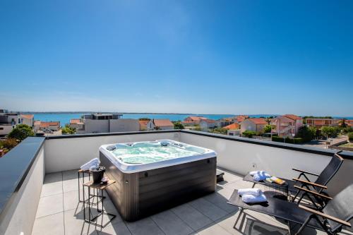a hot tub on a balcony with a view at Villa Restart Vrsi-Mulo with heated pool,sea view and jacuzzi in Vrsi