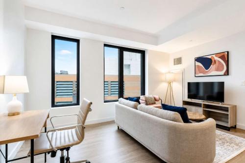 a living room with a couch and a table at Luxury Seaport Stay Rooftop & Pool in Boston
