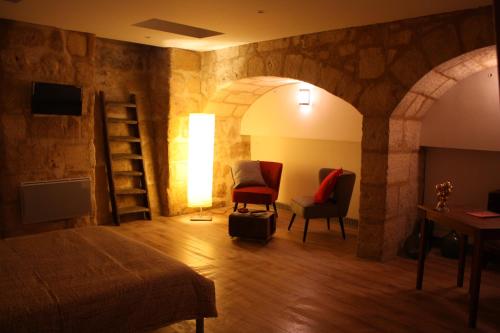a room with a bed and a chair and a lamp at Le Clos Beaufleury in Bordeaux