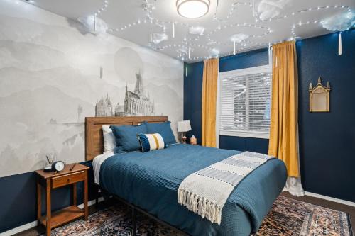 a bedroom with a blue bed and a wall with a mural at Library INN - Boutique Rooms - Free Breakfast - Hot Tub in Lava Hot Springs