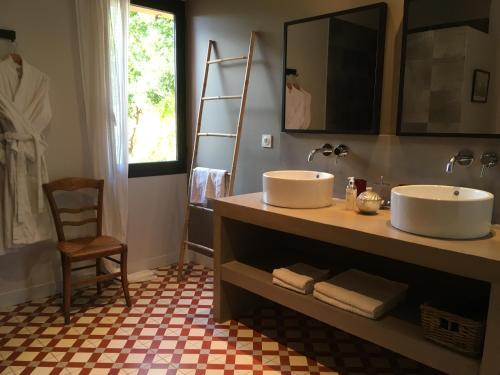 a bathroom with two sinks and a chair and a mirror at Clos Des Aspres in Ortaffa