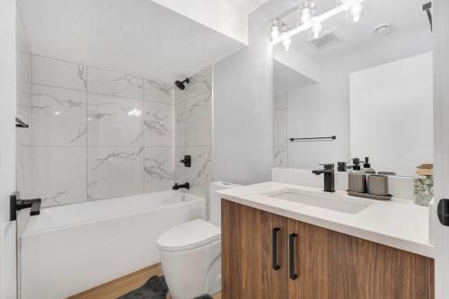 a bathroom with a sink and a toilet and a tub at 2 bedroom Cozy Secondary-Basement suite in Calgary