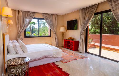 a bedroom with a bed and a large window at Mila Dyafa in Oulad Akkou