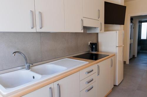 a kitchen with white cabinets and a sink at IL TRITONE in Marina di Bibbona