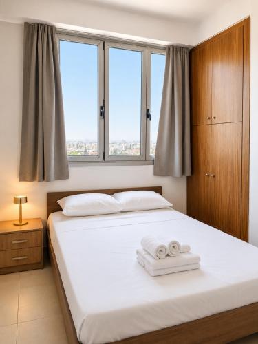 a bedroom with a bed with two towels on it at TOP RATED - PREMIUM Seaview 2-BDR-Apt in tallest building in Larnaca - 2 min Walk to Beach in Larnaca