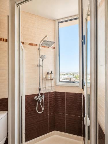 a bathroom with a shower with a window at TOP RATED - PREMIUM Seaview 2-BDR-Apt in tallest building in Larnaca - 2 min Walk to Beach in Larnaca